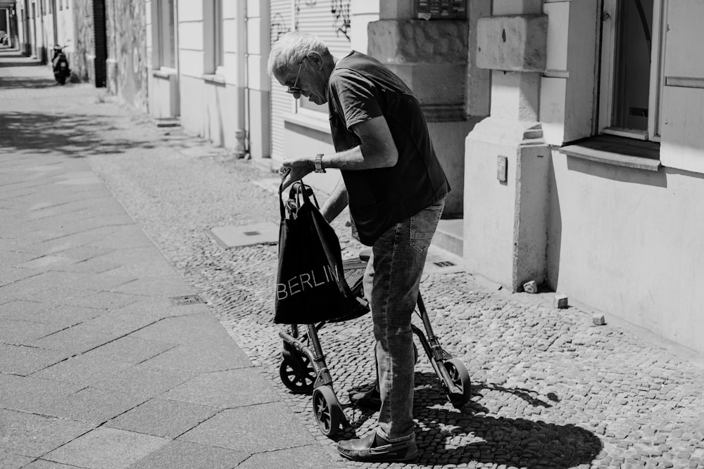 man in black t-shirt and gray pants riding on black and red bicycle