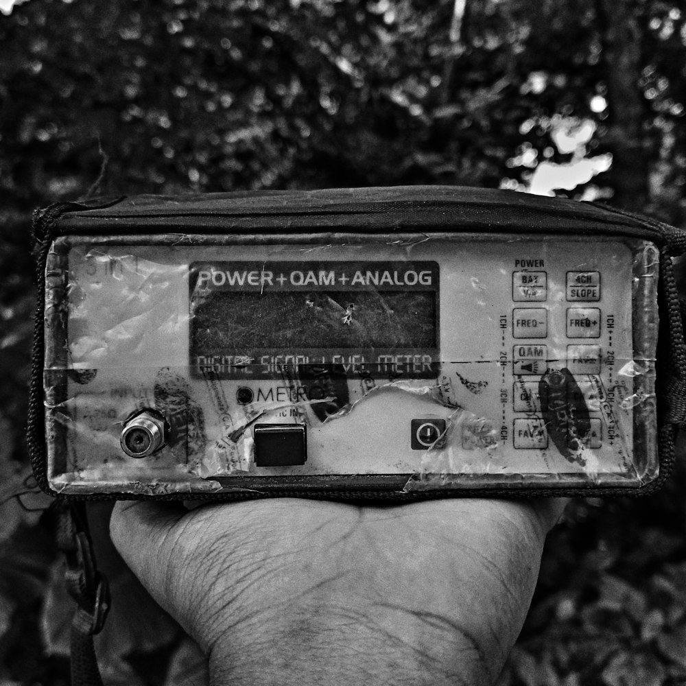 grayscale photo of person holding digital device