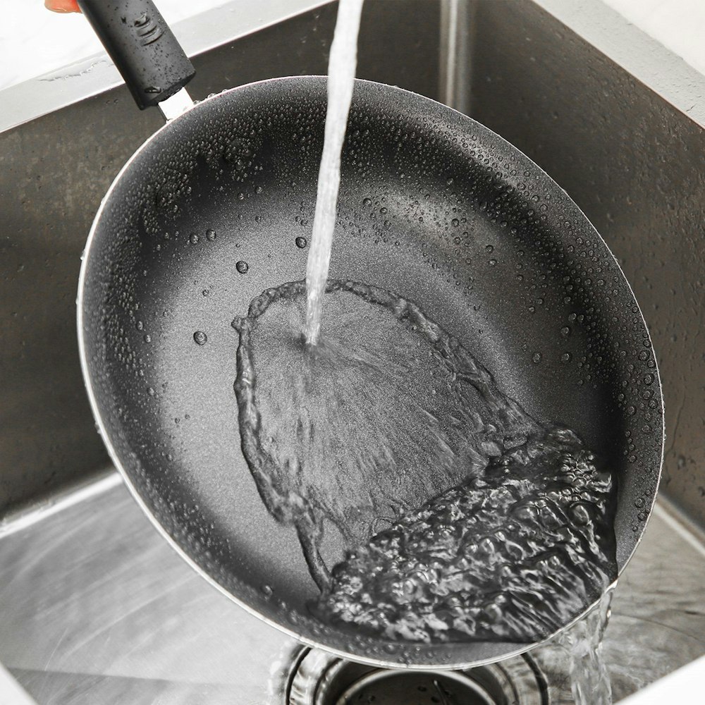 black cooking pan with silver spoon