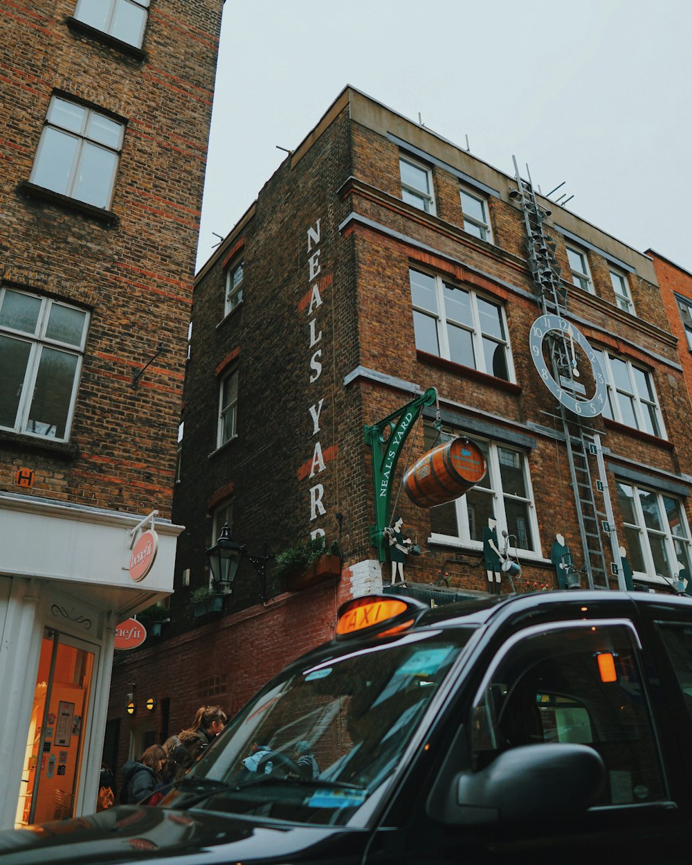 black car parked beside brown brick building