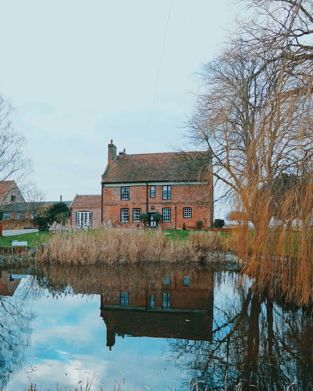 brown concrete house beside body of water during daytime