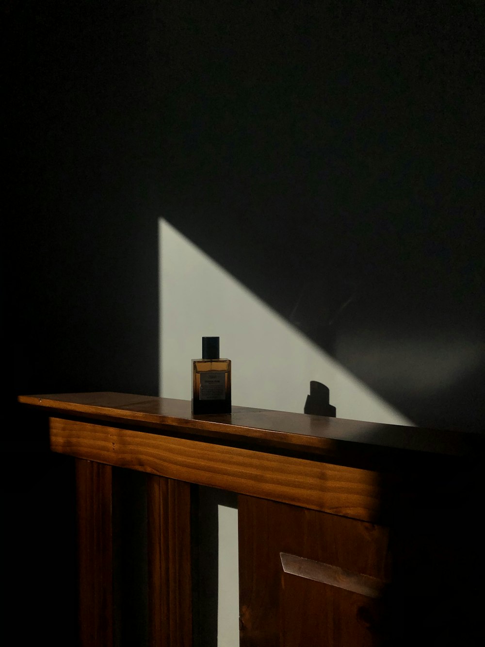 Mesa de madera marrón con botella negra en la parte superior