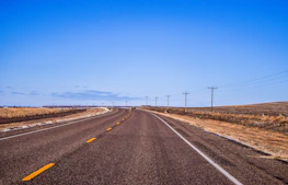 gray concrete road under blue sky during daytime
