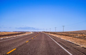 gray concrete road under blue sky during daytime