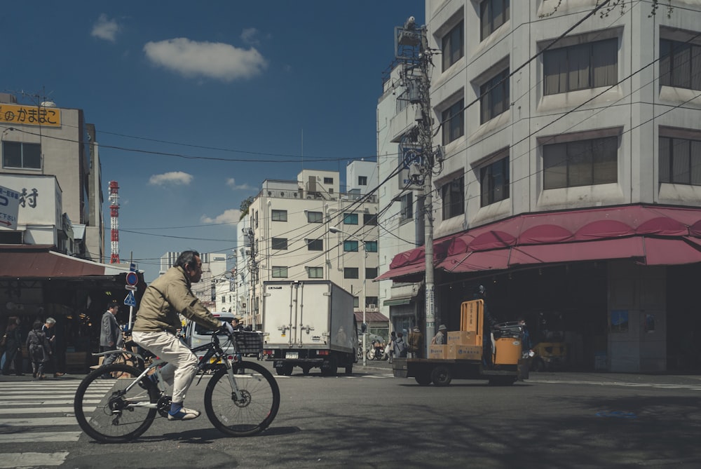 man in blue shirt riding bicycle on road during daytime