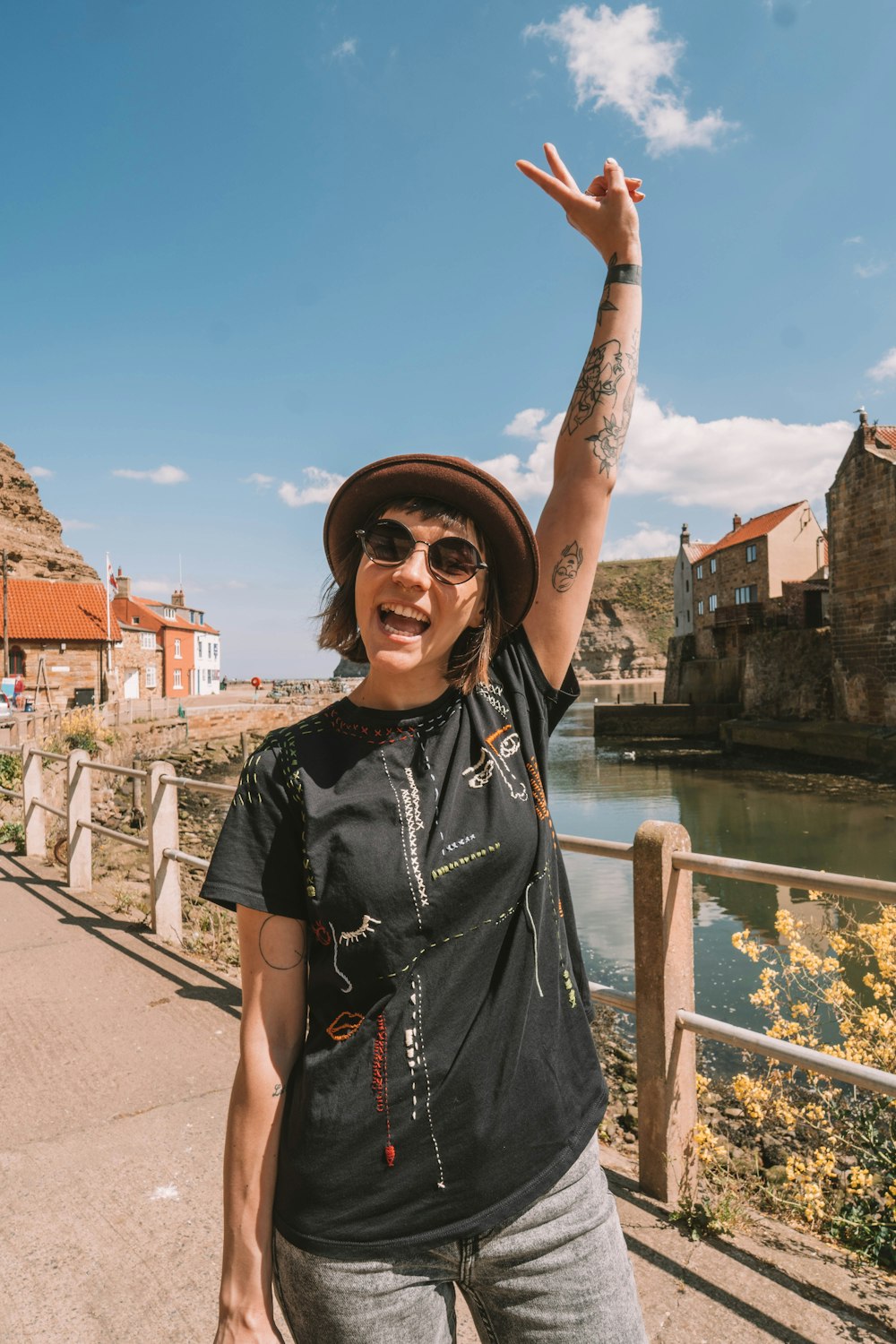 woman in black shirt and black cap standing near bridge during daytime