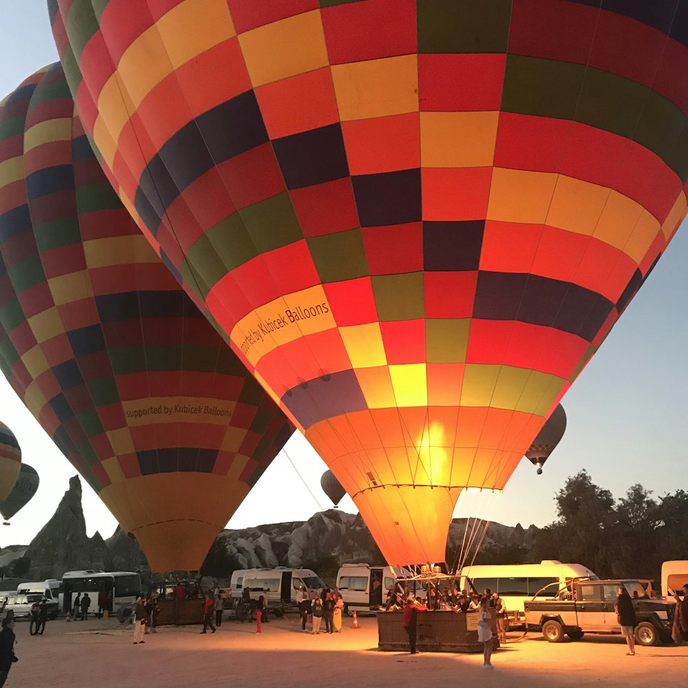 people standing near red yellow and blue hot air balloon during daytime