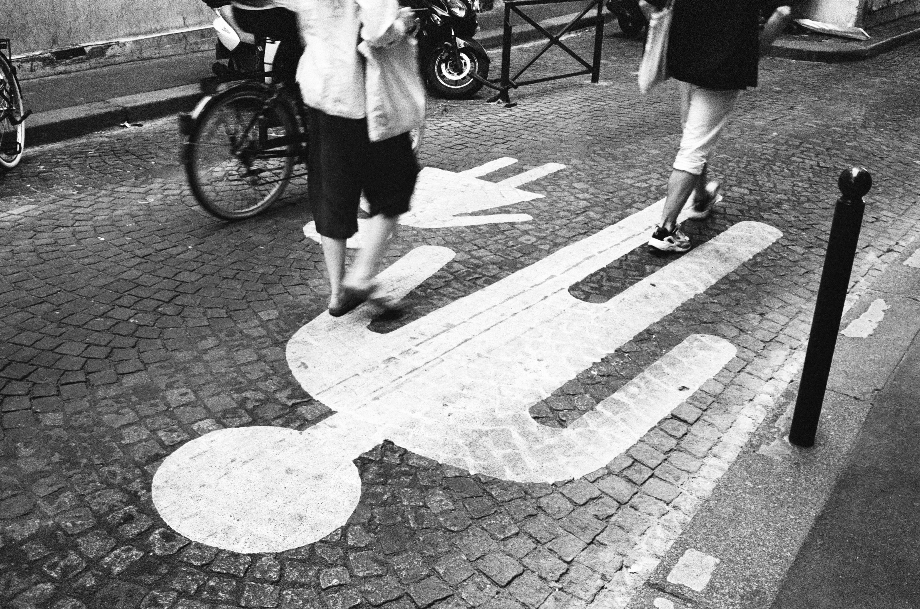 woman in white coat walking on sidewalk