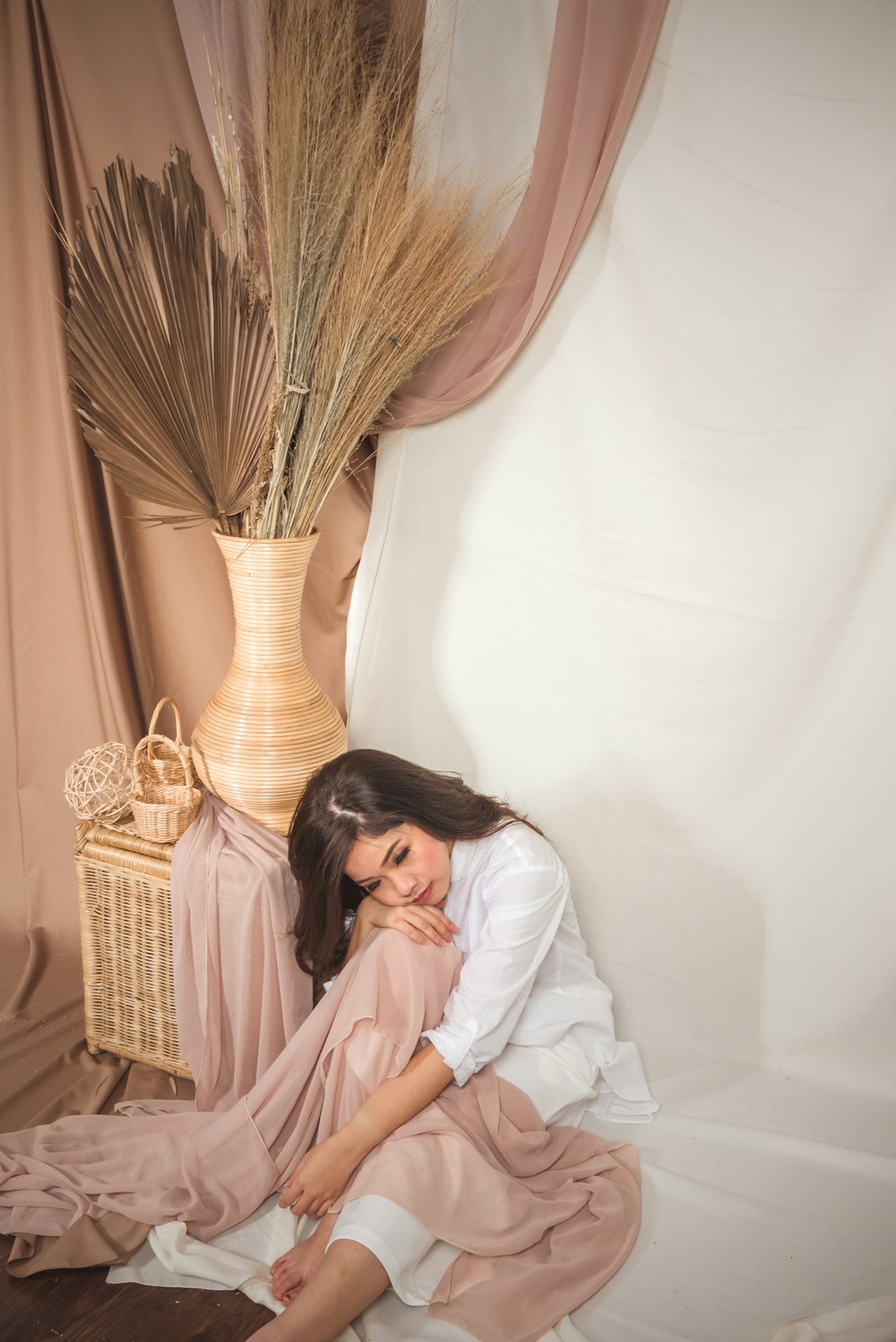 woman in white dress sitting on woven chair