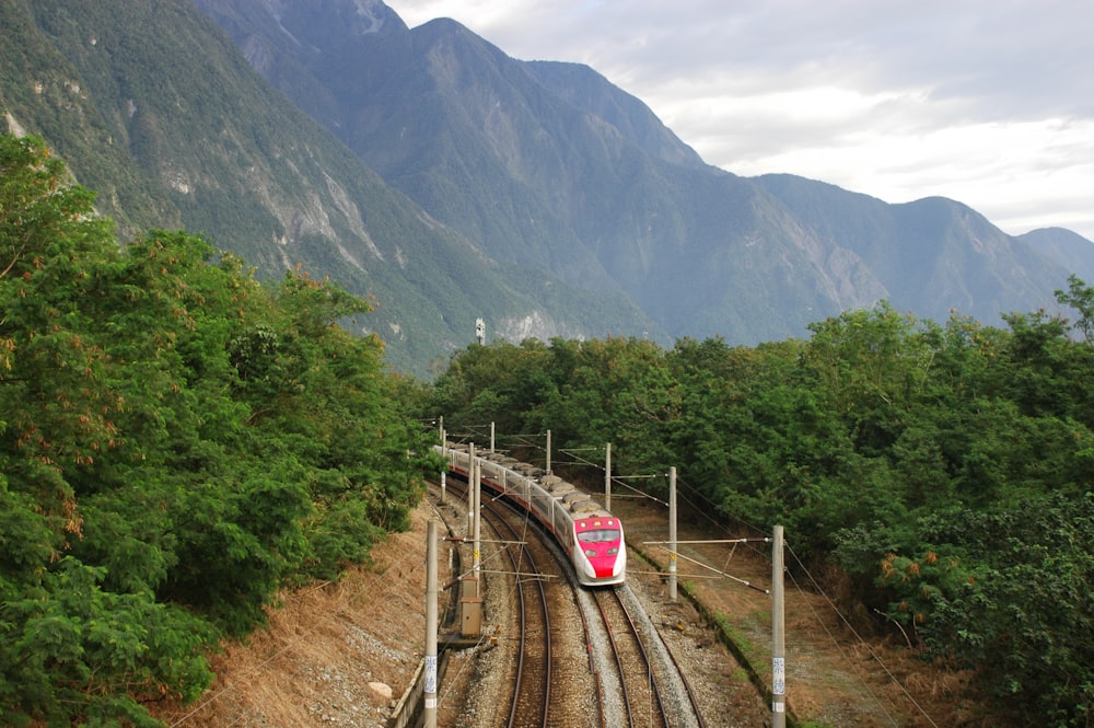 train rail near green mountain during daytime
