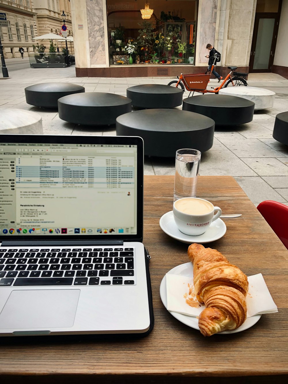 MacBook Pro junto a un cuenco de cerámica blanca con pan