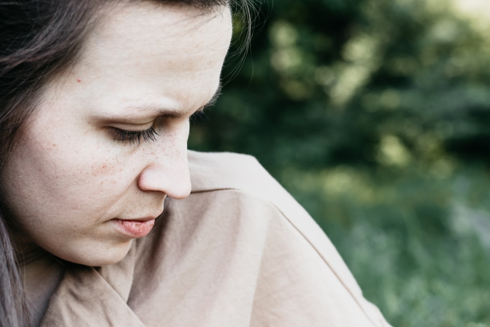 woman in brown shirt looking down