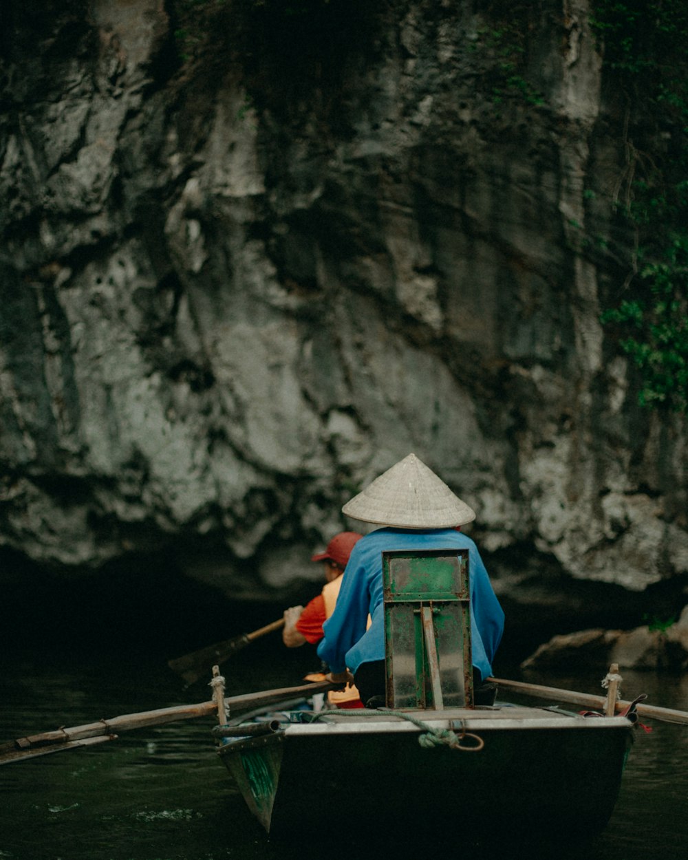 man in blue shirt sitting on boat on river during daytime