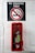 A sign indicating a no smoking area is positioned above a fire extinguisher enclosed in a red case, mounted on a white-painted wall.
