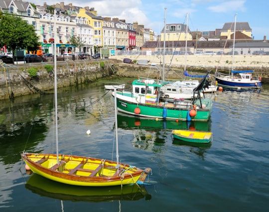 yellow and green boat on water during daytime in Cobh Ireland
