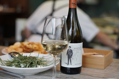 wine bottle beside wine glass on table