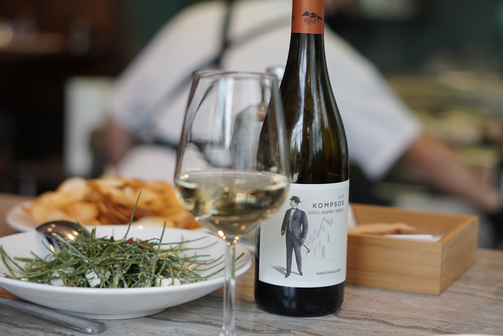 wine bottle beside wine glass on table