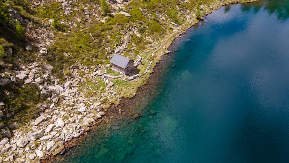 aerial view of house on hill beside body of water during daytime