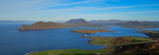 green grass field near body of water during daytime in Valentia Island Ireland