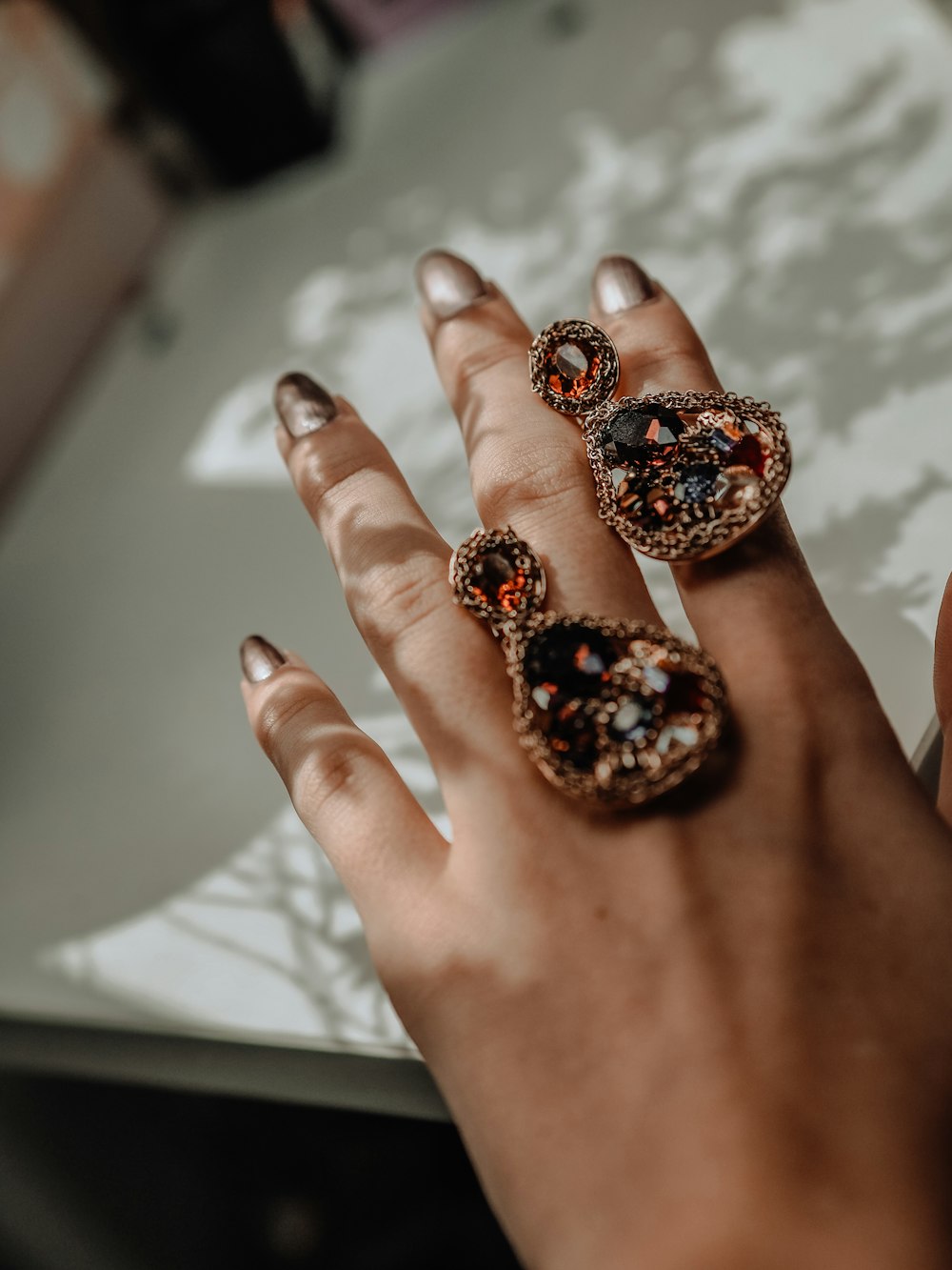 person with red and black floral nail polish