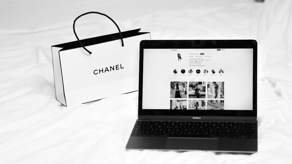 a laptop computer sitting on top of a white bed