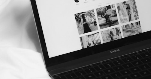 black laptop computer on white textile