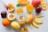 A vibrant assortment of colorful juice bottles arranged on a wooden table surrounded by fresh fruits.