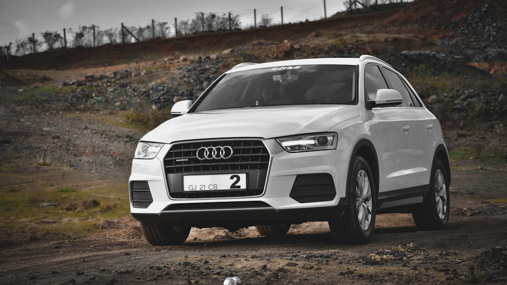 white audi a 4 on dirt road during daytime