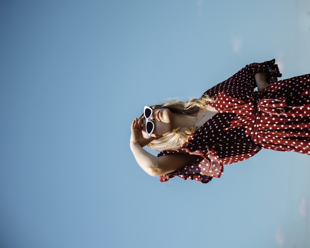 woman in red and white polka dot long sleeve shirt wearing white sunglasses