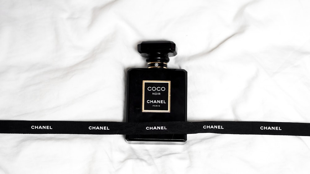 a bottle of chanel perfume sitting on top of a white sheet