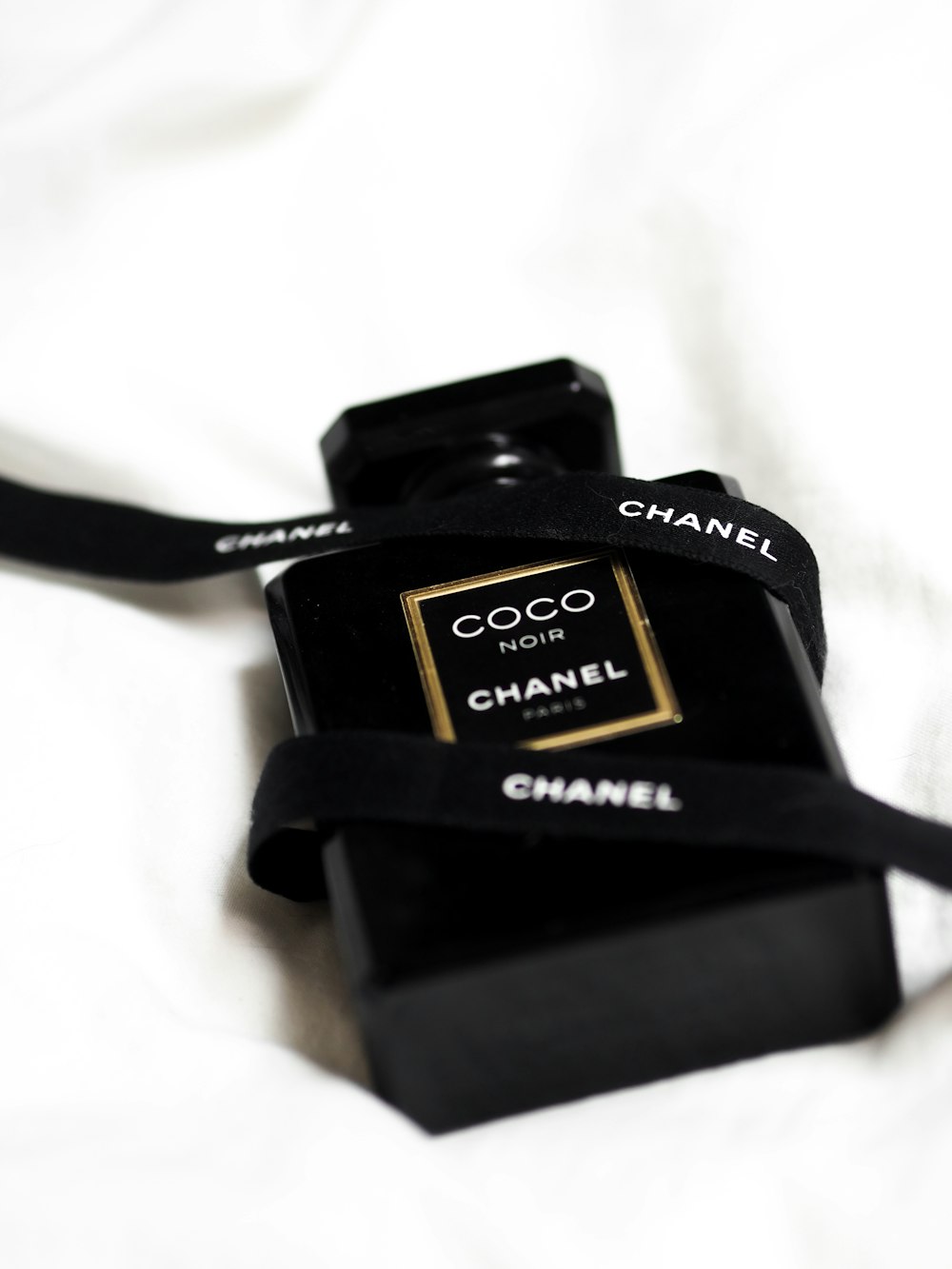 a chanel camera sitting on top of a bed