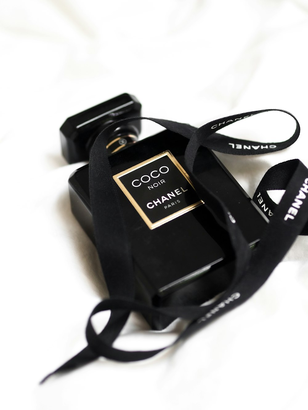 a bottle of chanel coco noir on a bed