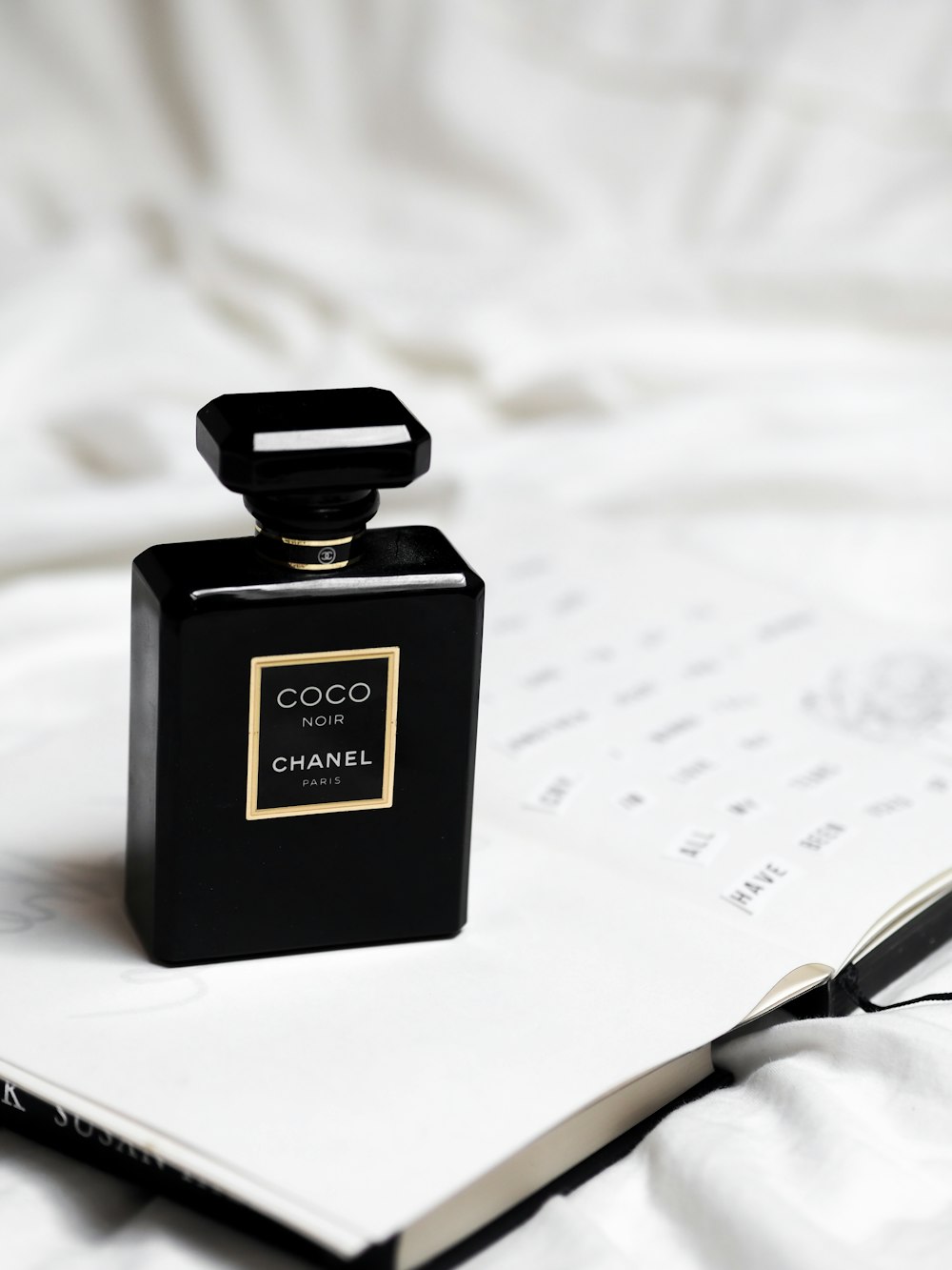 black and gold perfume bottle on white paper