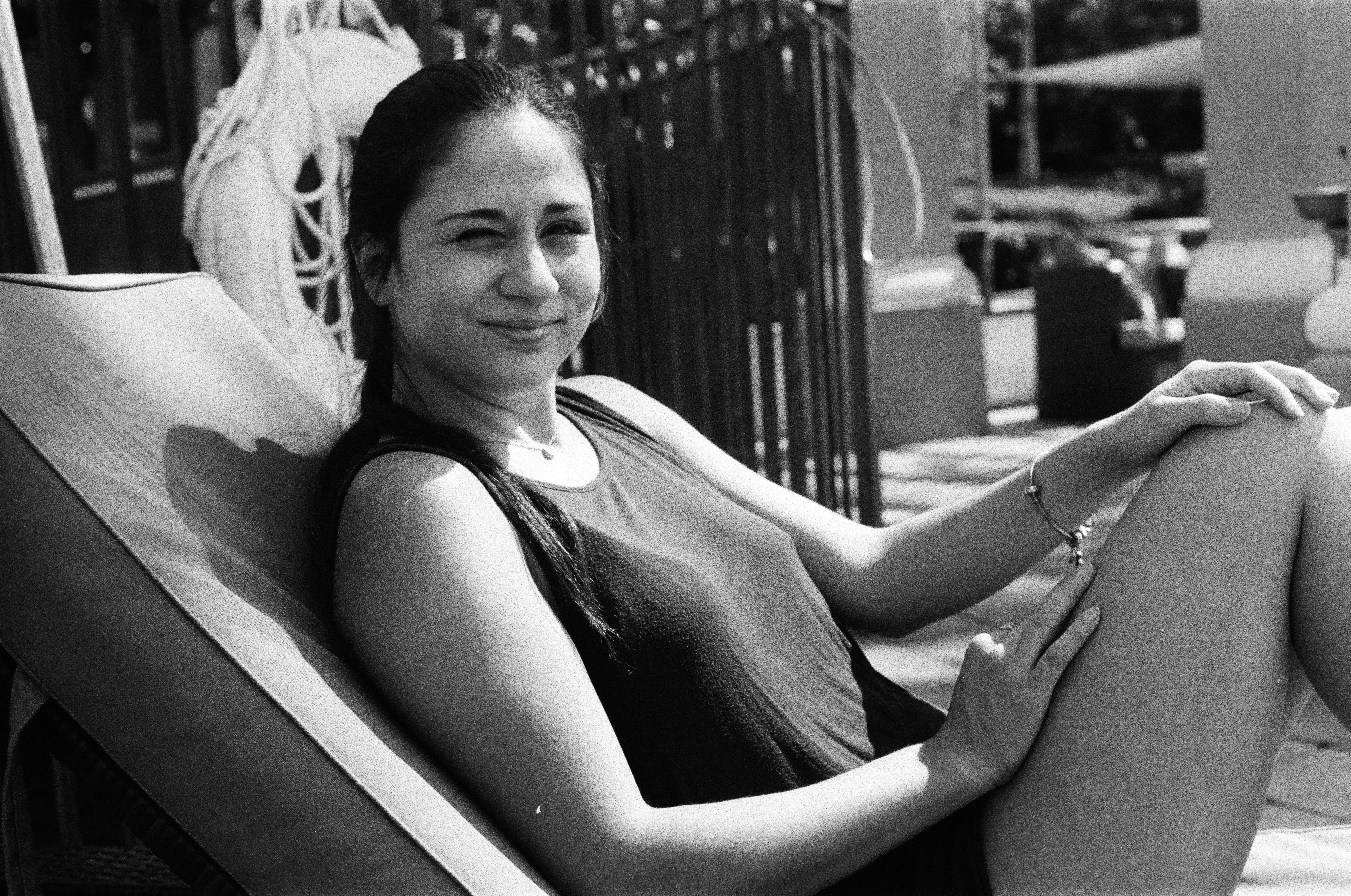 grayscale photo of woman in tank top sitting on chair