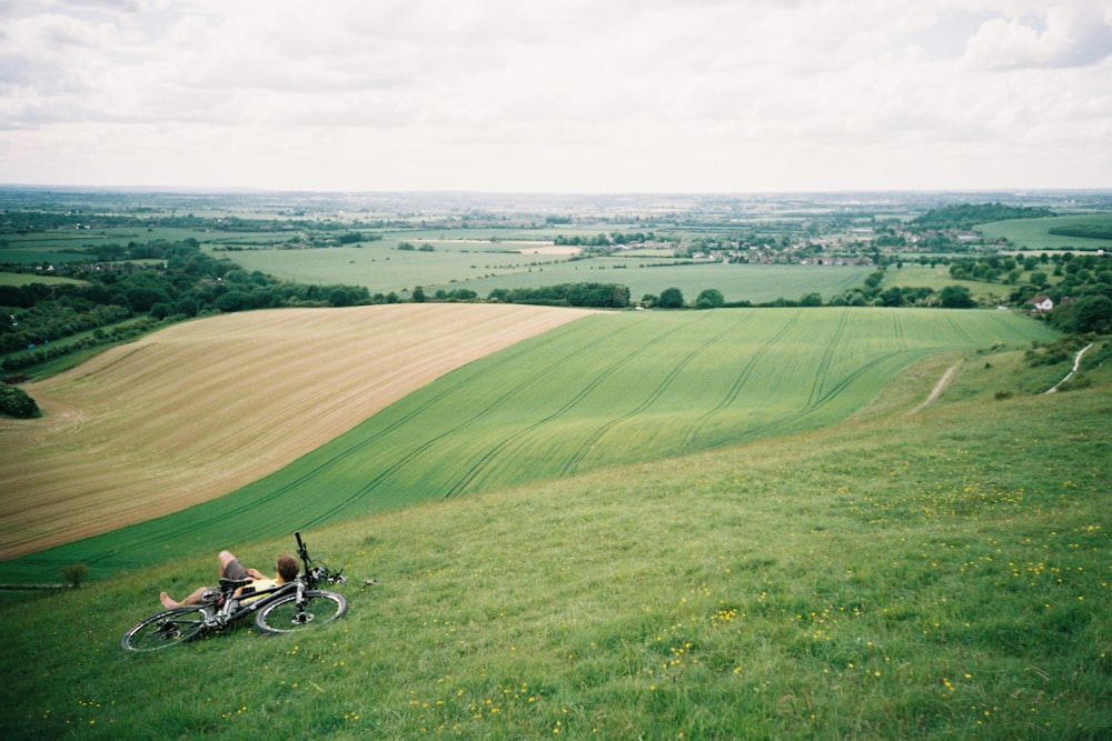 man riding motorcycle on green grass field during daytime