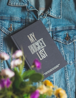 A Bucket List journal on a denim jacket