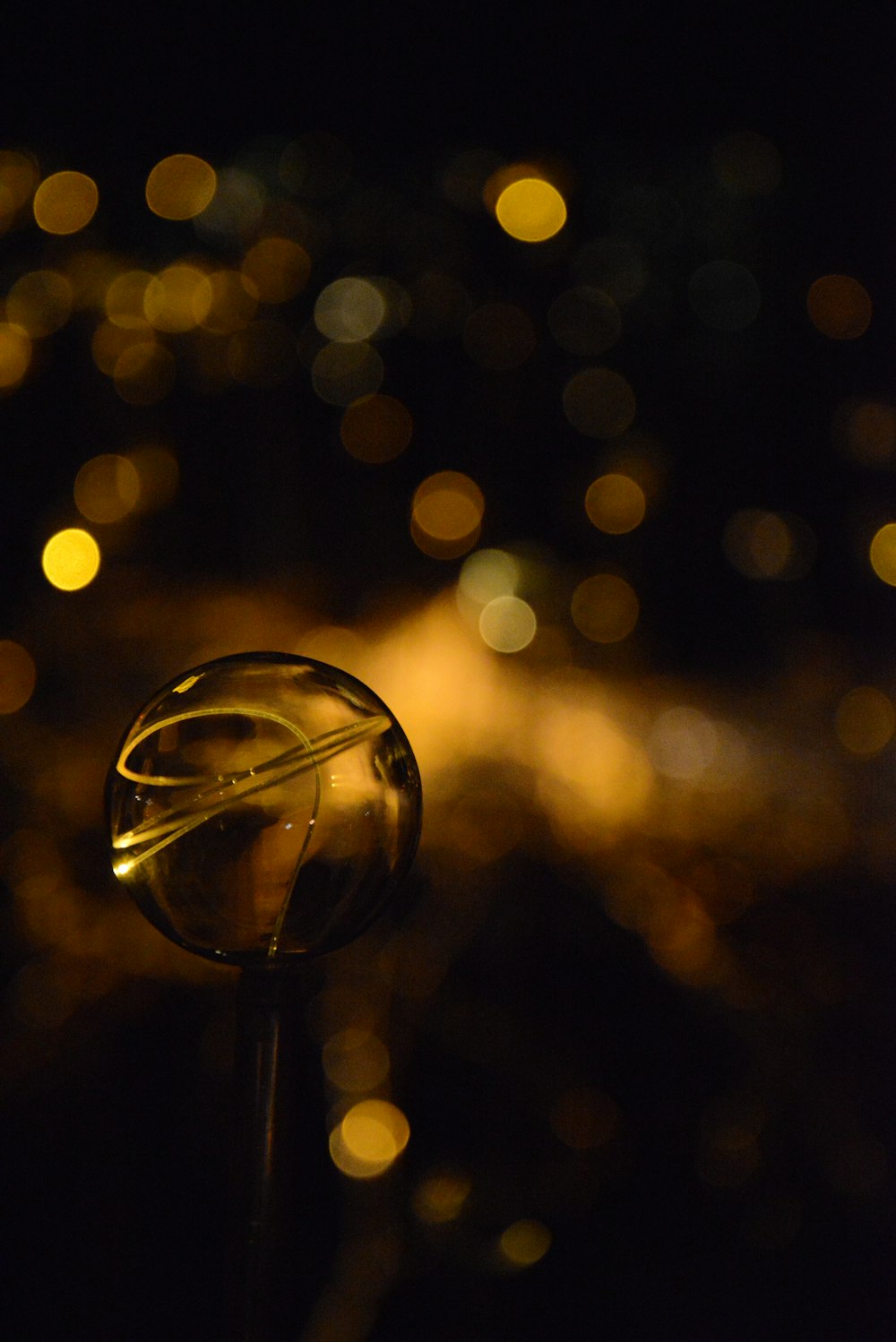 clear glass ball with yellow light bokeh
