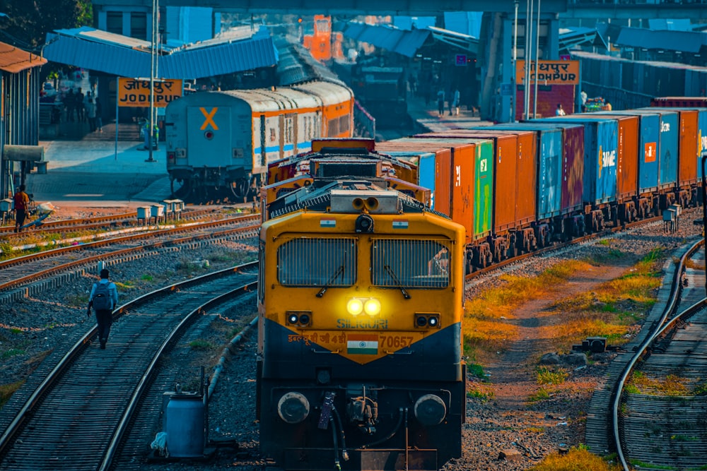 gelber und schwarzer Zug tagsüber auf Bahngleisen