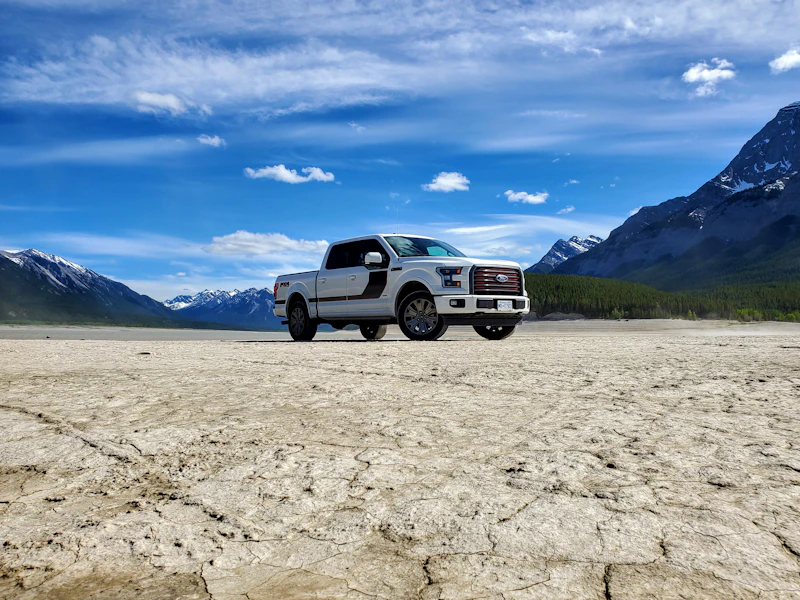 White 2017 Ford F-150 Lariat Special Edition pickup parked on a dry lakebed below mountains