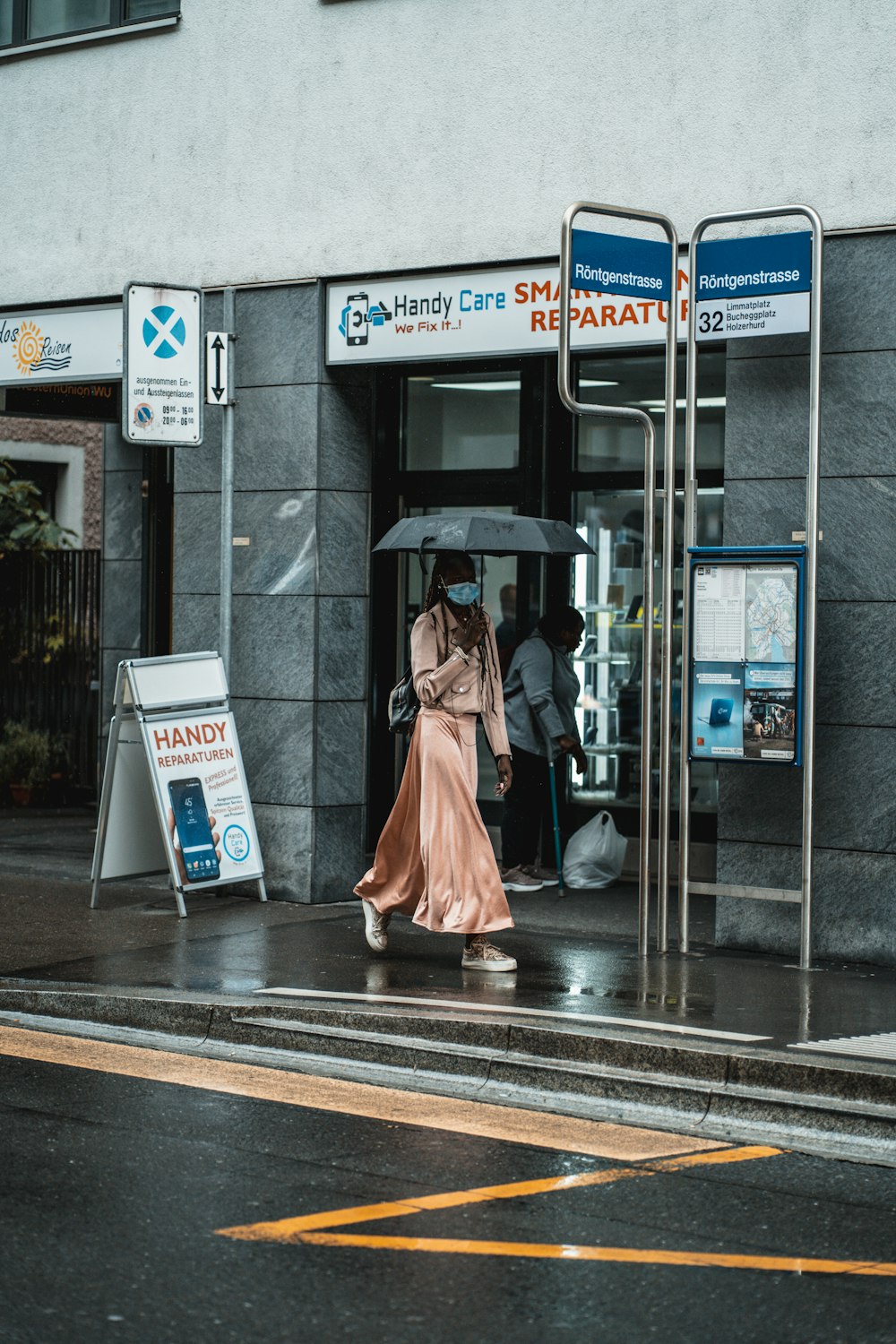 woman in pink dress walking on sidewalk during daytime