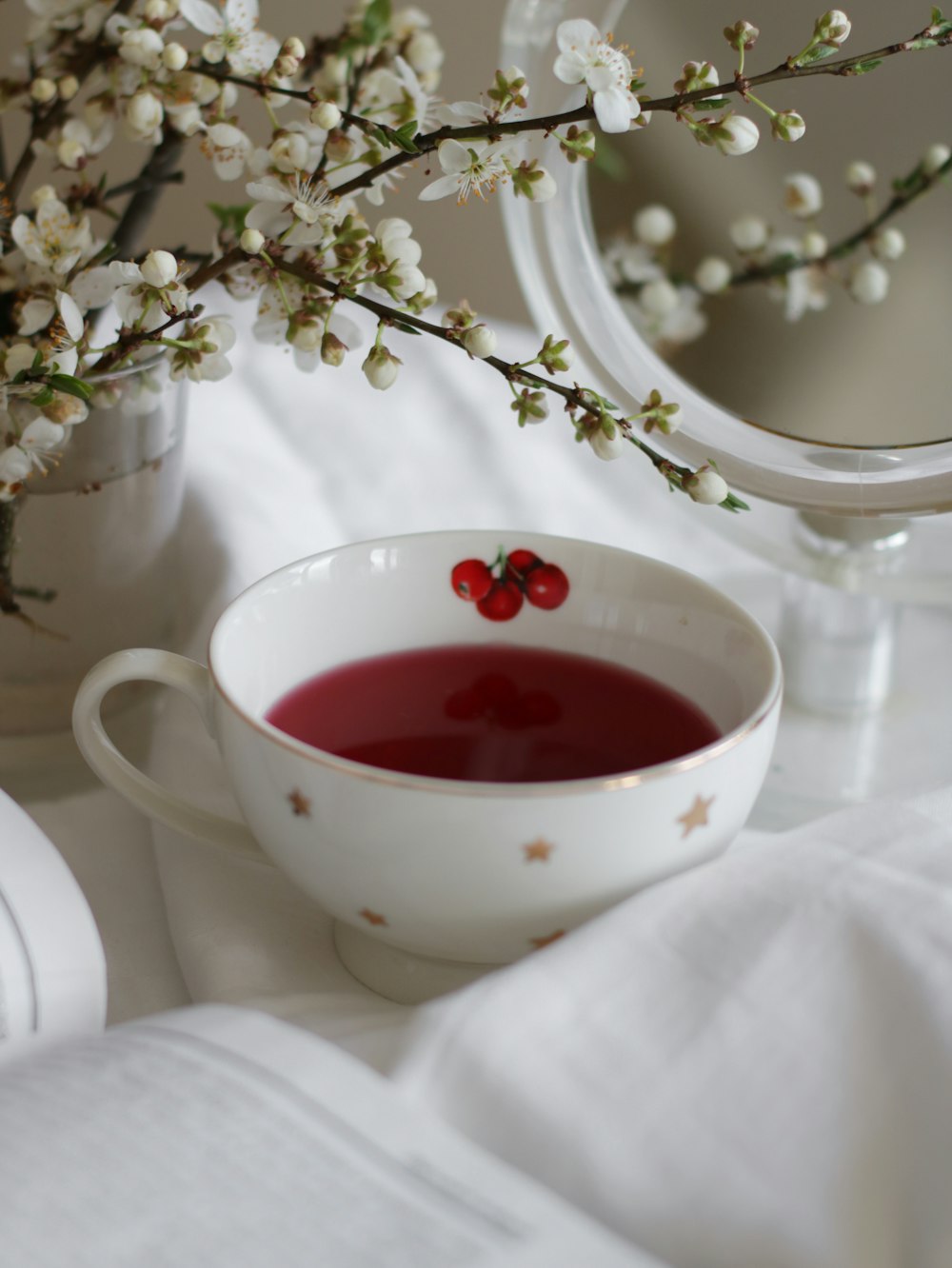 white ceramic teacup with red liquid inside