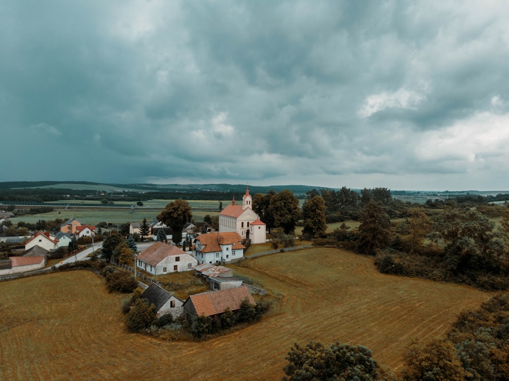 Weißes und braunes Betonhaus unter weißen Wolken und blauem Himmel tagsüber