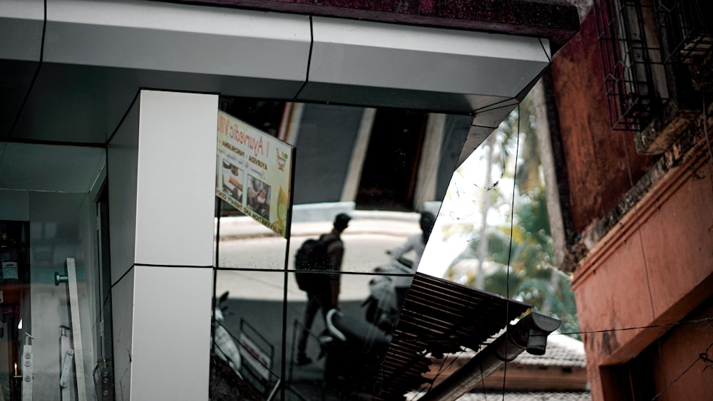 man in black jacket standing near glass window