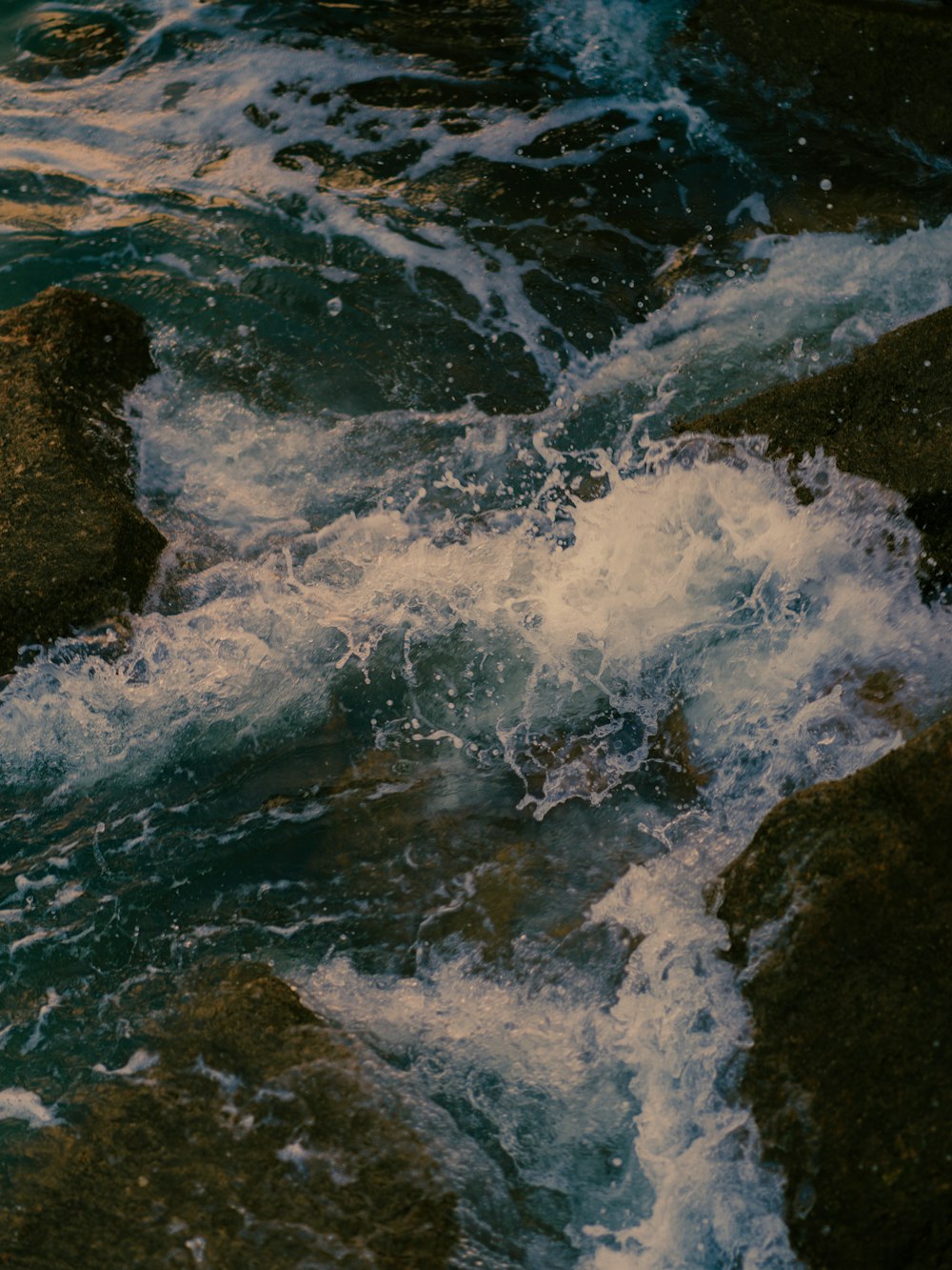 water waves hitting rocks during daytime