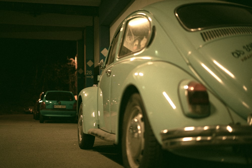 white volkswagen beetle parked on side of the road during night time