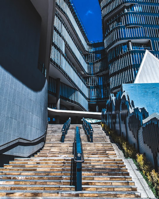 man in black jacket walking on sidewalk during daytime in Sandton South Africa