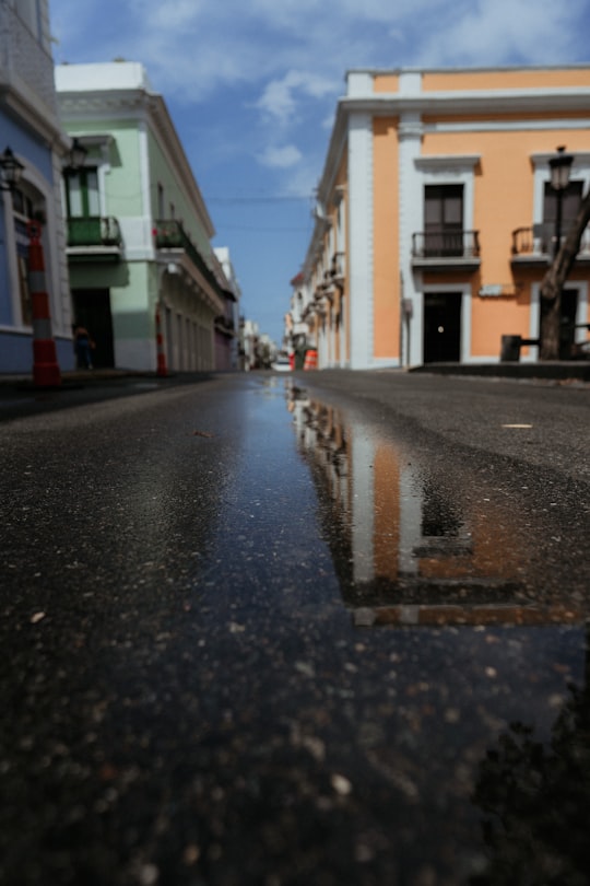 wet road in between buildings during daytime in Puerto Rico United States