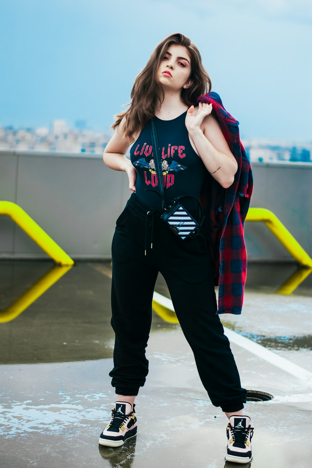 girl in blue and red zip up jacket and black pants standing on gray concrete floor