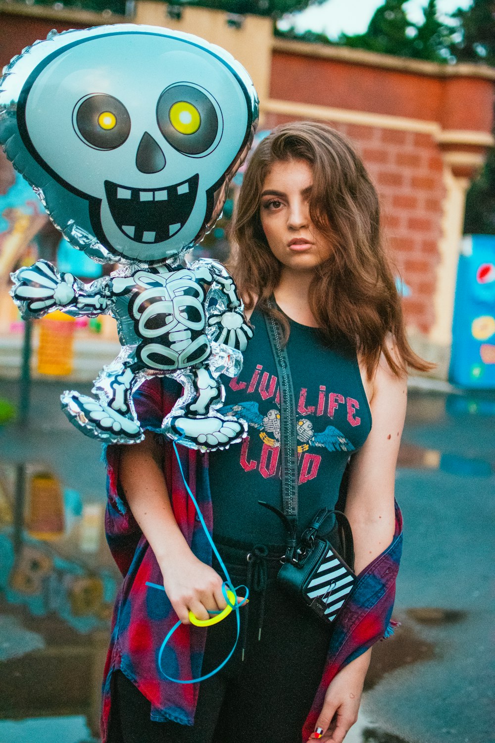 Mujer en camisa azul y blanca de Mickey Mouse sosteniendo una pelota de fútbol en blanco y negro