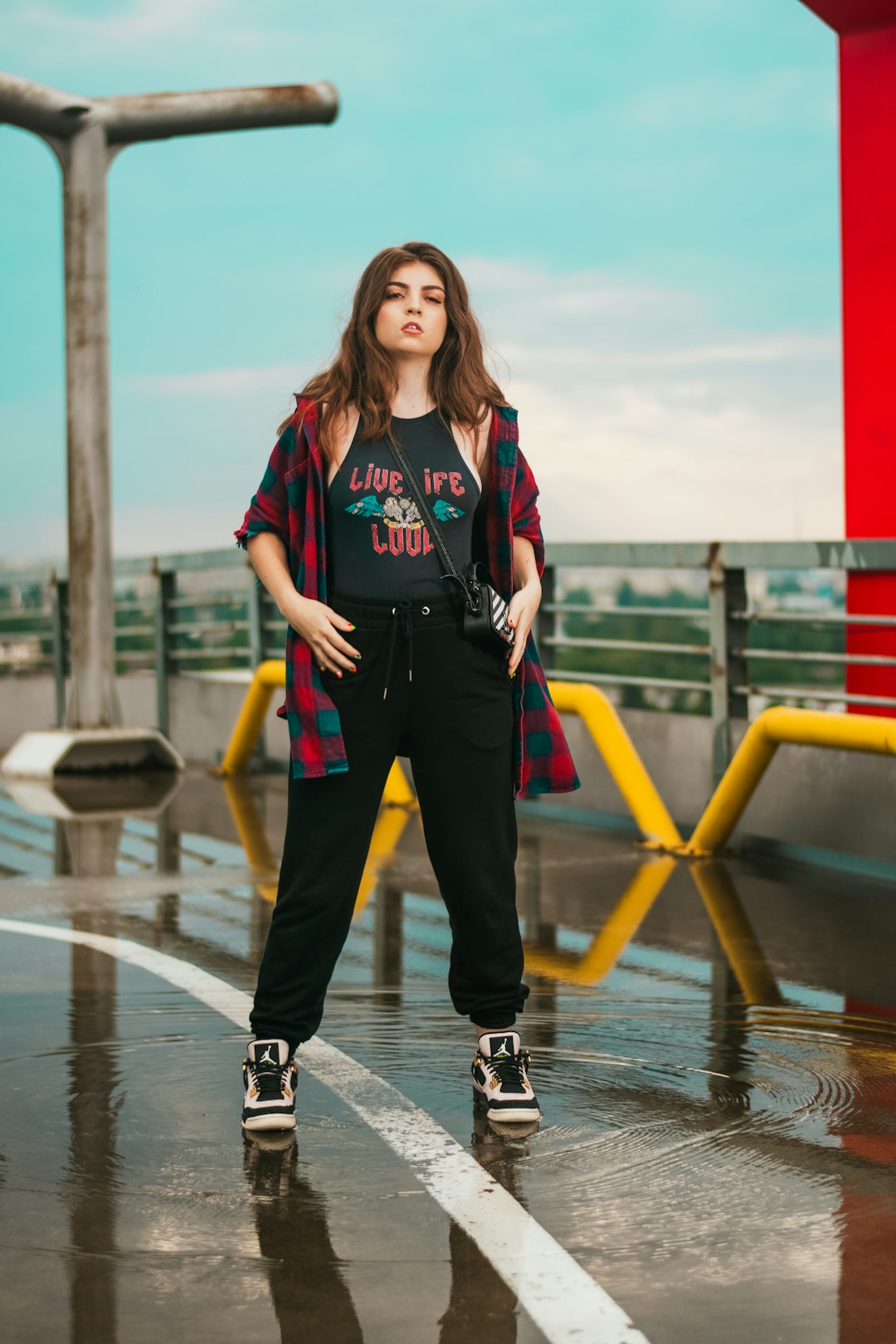 woman in red and blue zip up jacket and black pants sitting on yellow metal bench